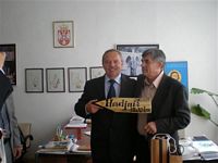 Wizyta w Szkole Średniej w Blace- dyrektor Szkoły i Burmistrz prezentują tabliczkę z napisem Chmielnik ( pisownia serbska) i odległością od Blace do Chmielnika  fot. T.Biernacki